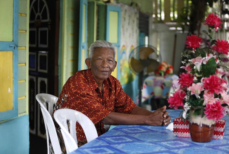 83-year-old Awe Ludin has been living in Kampung Buangkok for more than 50 years. He welcomes visitors to his courtyard, and even keeps pet roosters for schoolchildren to see. — TODAY pic