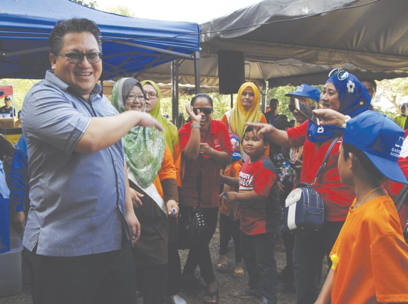 Nur Jazlan shares a candid moment with constituents in Taman Perling yesterday. u00e2u20acu201d Picture by Roslan Khamis