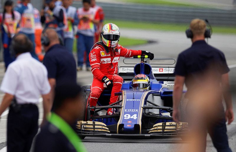 Ferrariu00e2u20acu2122s Sebastian Vettel hitches a ride back to the pit with Sauberu00e2u20acu2122s Pascal Wehrlein after Vettel crashed after the Malaysia Grand Prix in Sepang October 1, 2017. u00e2u20acu201d Reuters pic