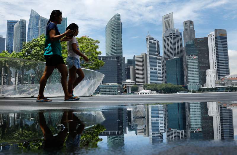 People pass the skyline of Singapore October 11, 2017. u00e2u20acu201d Reuters pic