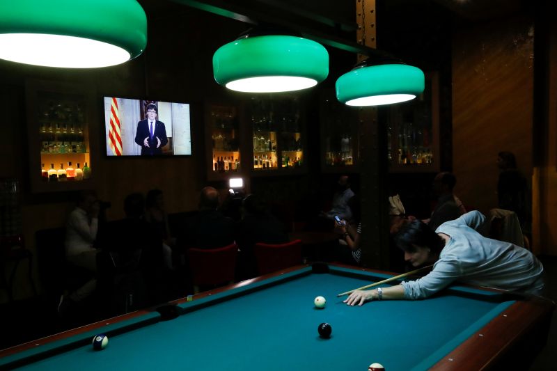 A woman plays snooker as Catalan President Carles Puigdemont makes a televised statement in Barcelona, Spain, October 4, 2017. u00e2u20acu201d Reuters pic