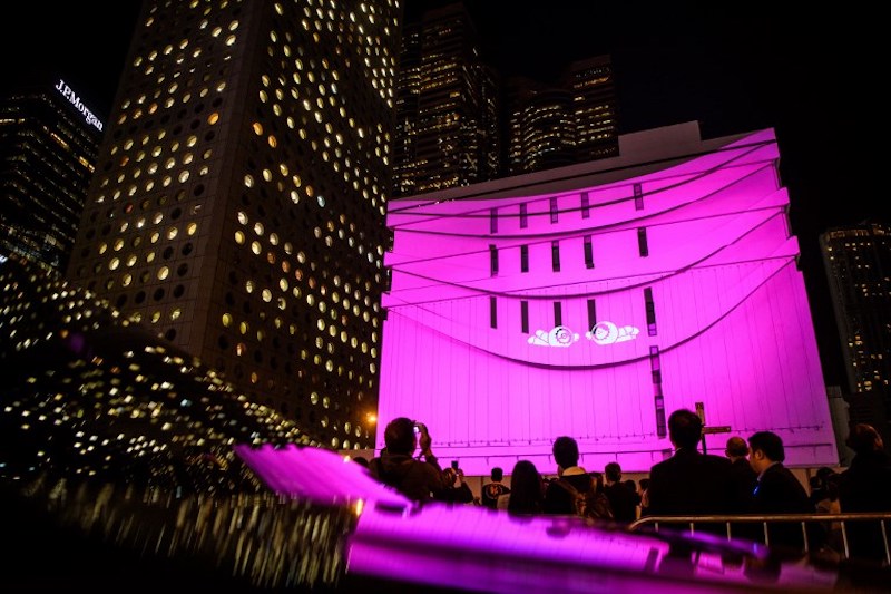 People watch ‘The Anooki Shake Up’ by French artists Moetu Batlle and David Passegand being projected onto the General Post Office building during the opening of Lumieres Hong Kong November 23, 2017. — AFP pic