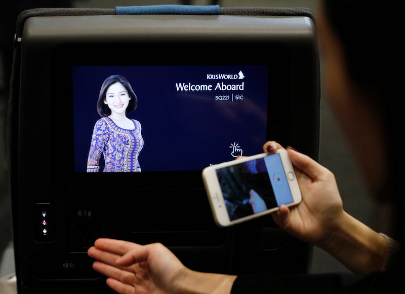 A guest takes photos of the inflight entertainment system on the newly launched Economy Class cabin seat during a Singapore Airlines event in Singapore November 2, 2017. — Reuters pic