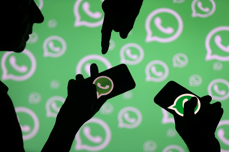 Men pose with smartphones in front of displayed Whatsapp logo in this illustration September 14, 2017. u00e2u20acu201d Reuters pic