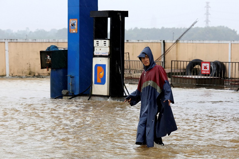 A man walks along a flooded petrol station after typhoon Damrey hits Vietnam in Hue city, Vietnam November 5, 2017. u00e2u20acu201d Reuters pic