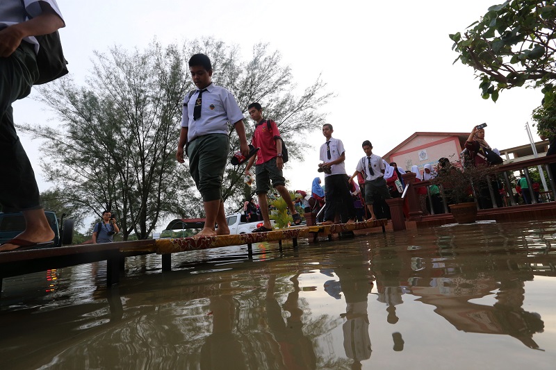 Students using tables to cross the flood waters to sit for their SPM Examination at Sekolah Menengah Kebangsaan Datuk Ahmad Said in Penang November 6, 2017. u00e2u20acu201d Picture by Sayuti Zainudin