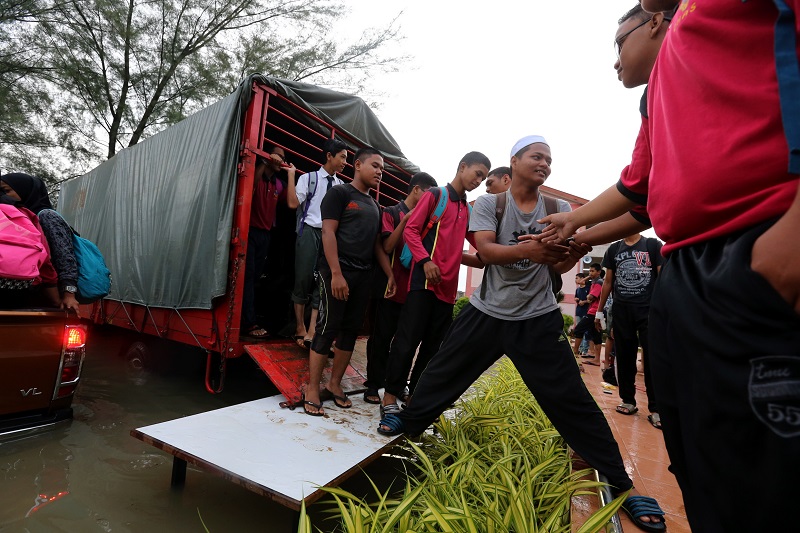 Students alight from a truck with the aid of a u00e2u20acu02dcbridgeu00e2u20acu2122 formed using tables in order to get to their school for the SPM Examinations at Sekolah Menengah Kebangsaan Datuk Ahmad Said in Penang November 6, 2017. u00e2u20acu201d Picture by Sayuti Zainudin