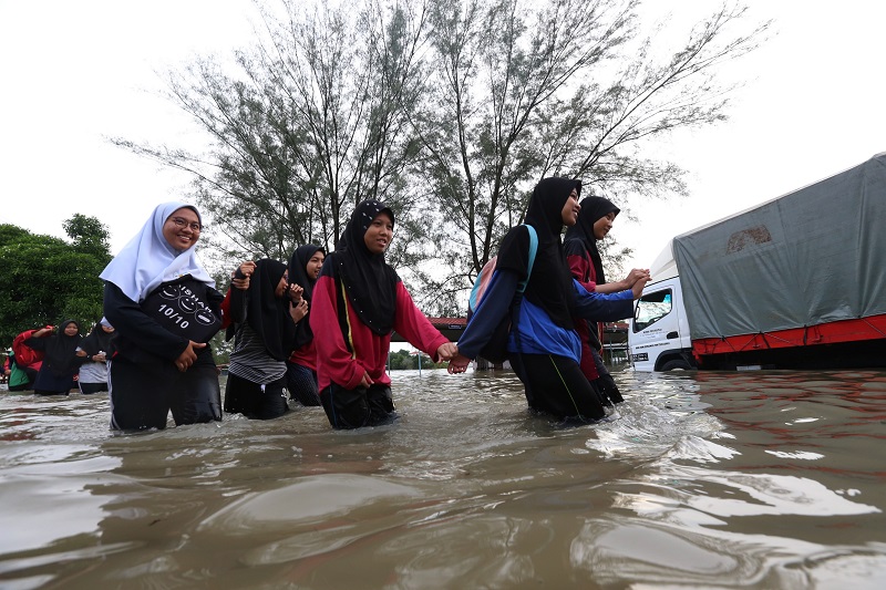 Students wade across waist-deep flood waters in order to get to their school for the SPM Examinations at Sekolah Menengah Kebangsaan Datuk Ahmad Said in Penang November 6, 2017. u00e2u20acu201d Picture by Sayuti Zainudin