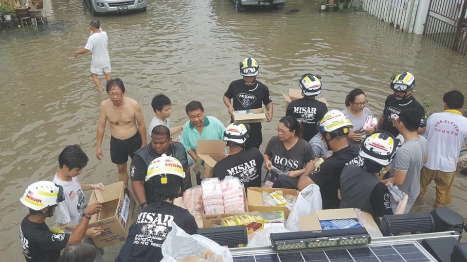 Petronas staff offloading some much-needed items in Kepala Batas. u00e2u20acu201d Picture by Malay Mail