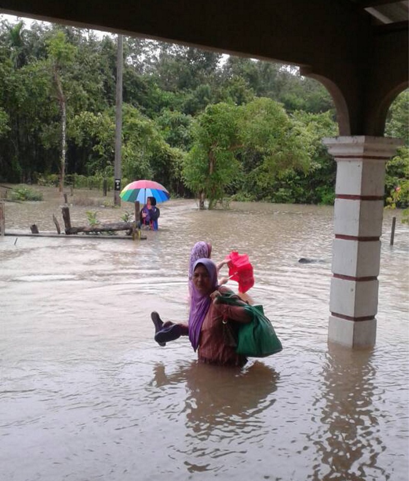 Mehammad Roslanu00e2u20acu2122s mother Rugayah Ali, 65, is forced out of her house after it is partly submerged by flood water. u00e2u20acu201d Picture by Mehammad Roslan Ahmad