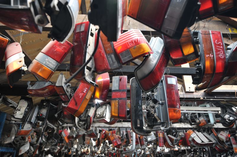 Rows of car lights hang from the ceiling of an auto parts shop.