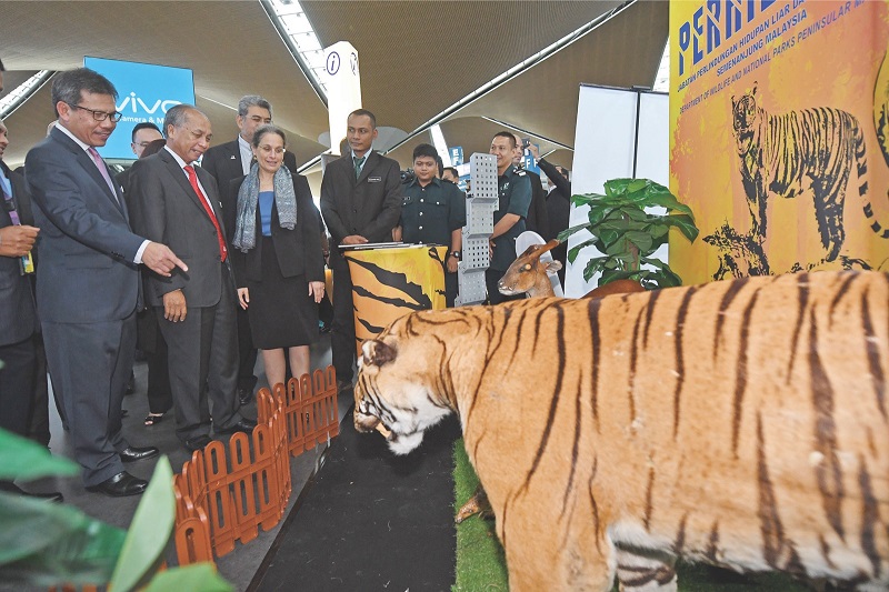 Datuk Masir Kujat (second from left) and Kamala Shirin Lakhdhir (third left) look at the wildlife exhibition during the roadshow. u00e2u20acu201d Picture by Bernama
