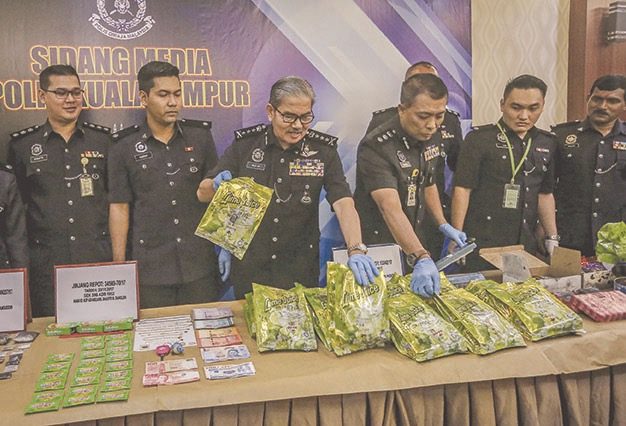 City police chief Commissioner Datuk Mazlan Lazim (centre) flanked by officers with packets of the seized drug powder. u00e2u20acu201d Bernama pic