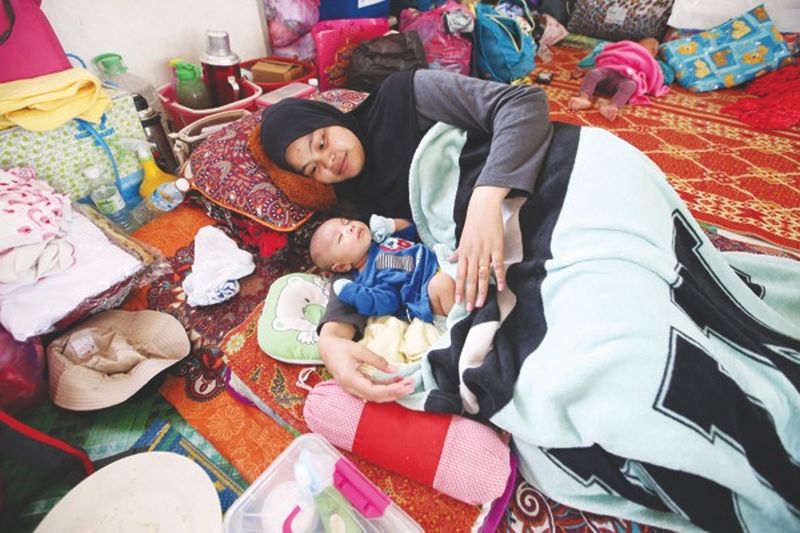 Nur Hakimah lies next to Muhammad Ammar at their relief centreu00e2u20acu2122s makeshift bed. u00e2u20acu2022 Malay Mail pic