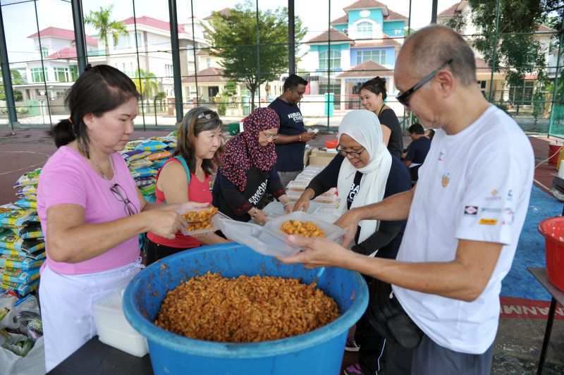 People of different ages, races and backgrounds coming together at Kembara Kitchen to help flood victims.