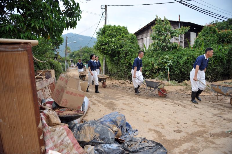 Tzu Chi Society volunteers helping to clear out mud at the Kampung Sheikh Madar.
