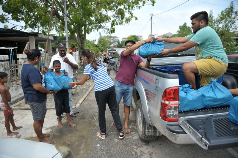 Volunteers of Amritesware Foundation handing out food at Taman Seri Rambai in Bukit Mertajam.
