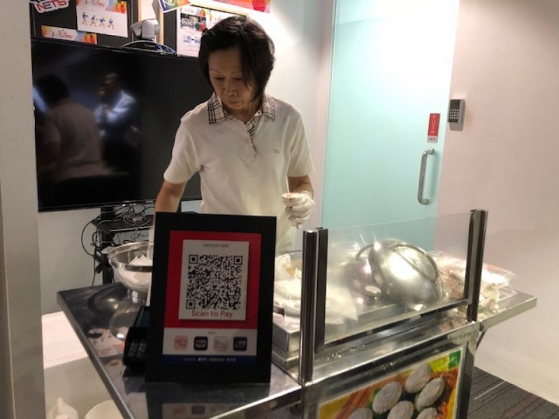 Customers of seven banks here will progressively be able to pay for their purchases at hawker centres and other food stalls using NETS QR code payments. u00e2u20acu201d TODAY pic