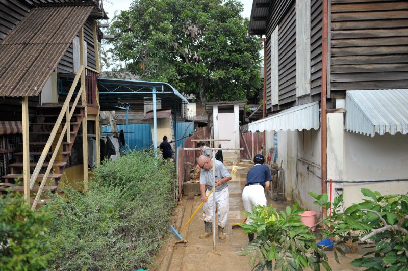 Tzu Chi Society volunteers helping to clean the mud from Tho You Seng's house in Kampung Sheikh Madar. u00e2u20acu2022 Picture by KE Ooi
