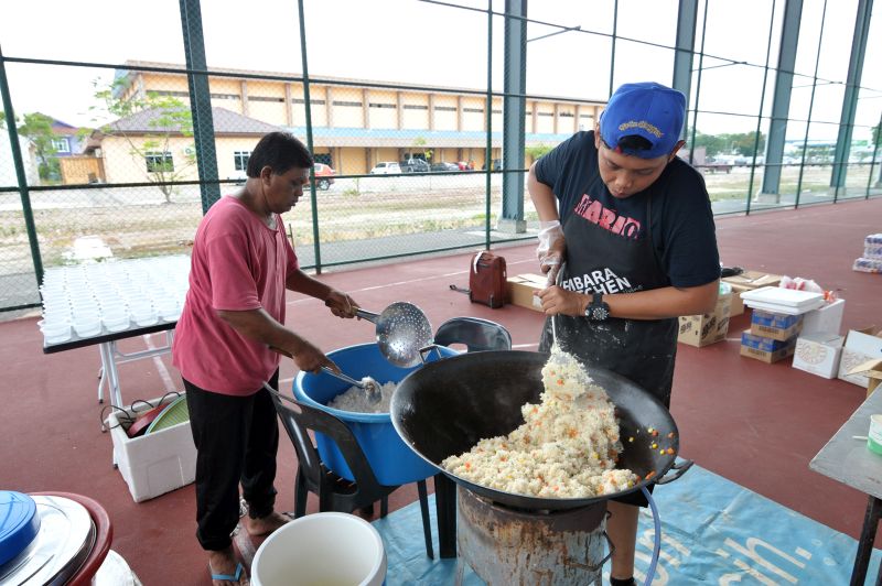 Kembara Kitchen volunteers cooking for about 200 people in their makeshift kitchen at the futsal court of the Sungai Besar flood relief centre on November 6, 2017. 