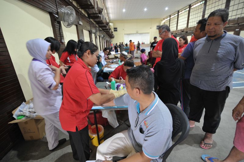 Medical staff are pictured providing free medical care to evacuees at the Sungai Besar flood relief centre on November 6, 2017.