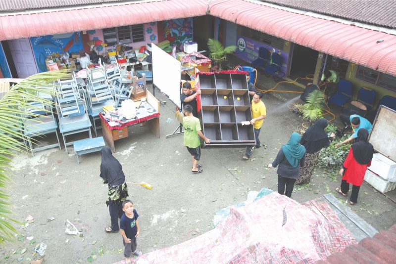 Volunteers assist with the cleanup and removal of damaged furniture at the Pasti Al-Mansur kindergarten. u00e2u20acu201d Pictures by Azinuddin Ghazali