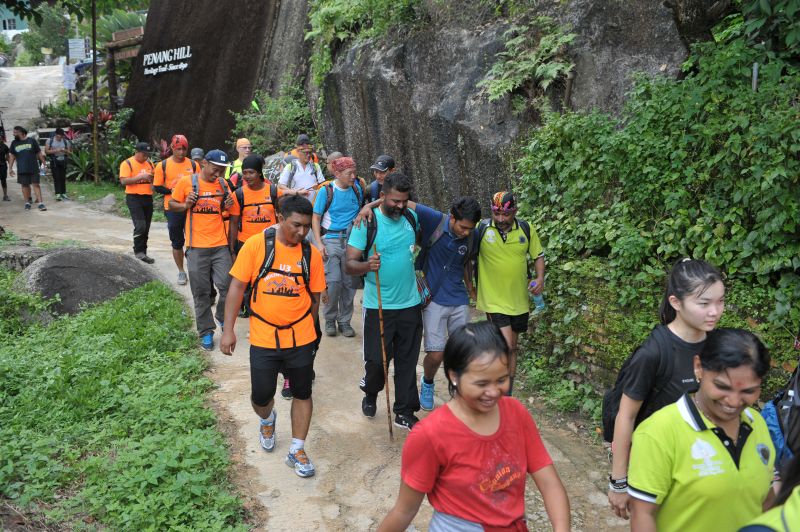 The hikers and the FRU personnel (in orange) helping the 12 people stranded on Penang Hill to hike down.