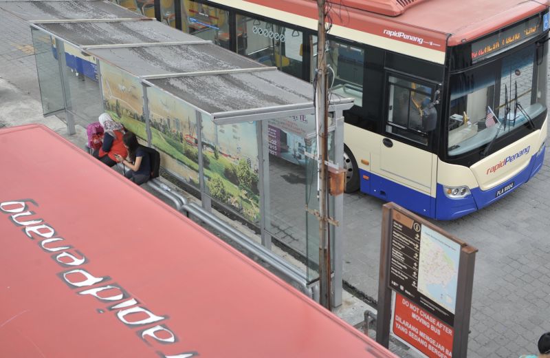 People are seen waiting for the bus at a bus stop in Geroge Town November 2, 2017. u00e2u20acu2022 Picture by KE Ooi