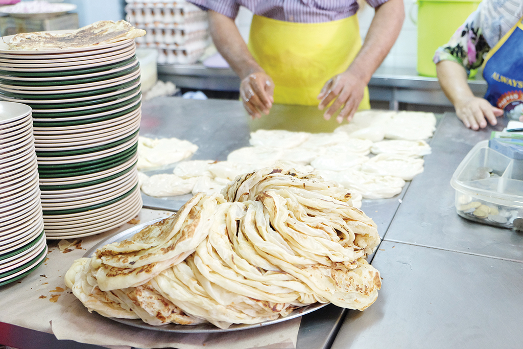 A Mansion Tea Stall worker prepares roti for patrons. 