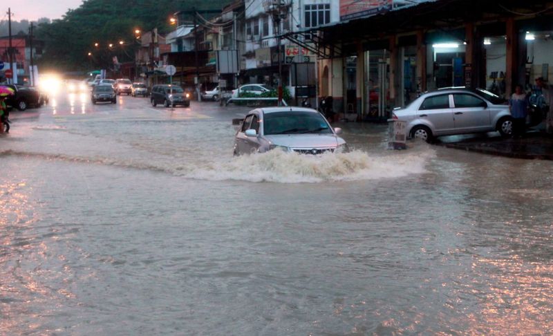 A car going through flood waters in Temiang. Low-lying areas were inundated by flash floods in Seremban. u00e2u20acu2022 Bernama pic