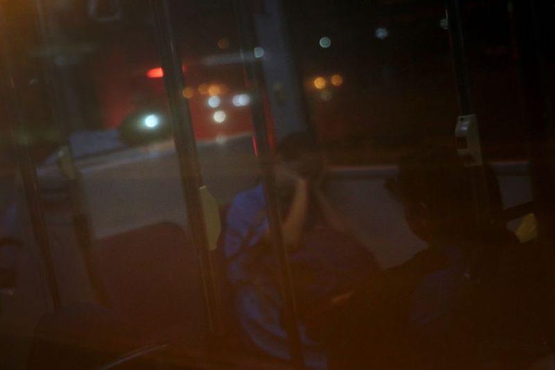 A student, seen reflected in a bus window, sleeps on board a bus, during a traffic jam along the Causeway, en route from Johor Bahru to Singapore in the morning on October 25, 2017. u00e2u20acu201d TODAY pic