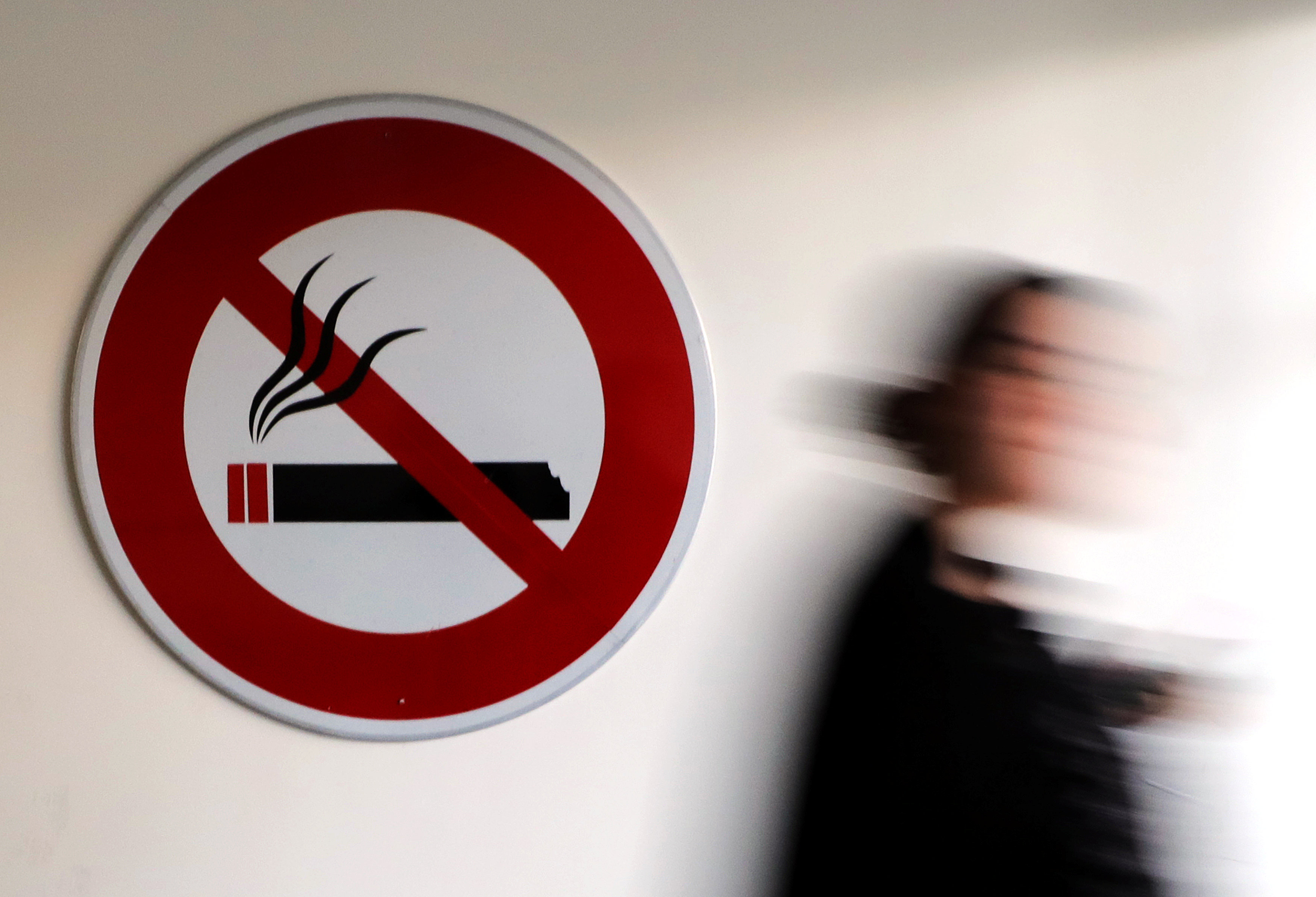 A woman walks past a no-smoking sign in Nice, France, November 8, 2017. u00e2u20acu201d Reuters pic 