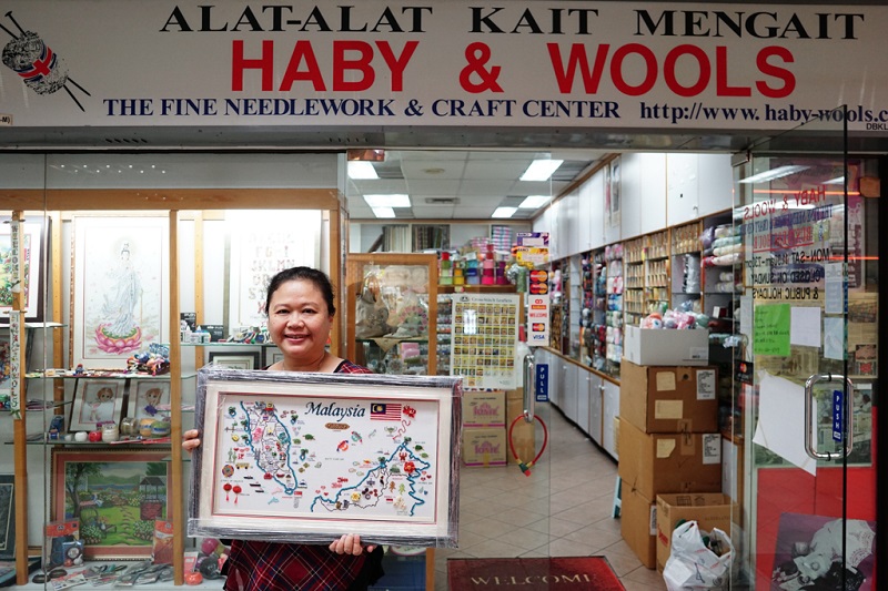 Third generation owner of Haby & Wools Jenny Lee, 45, poses with one of her artworks in front of her shop in Ampang Park shopping centre in Kuala Lumpur.