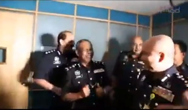 Screen capture of the Facebook video showing the police officers singing while doing a little jig. 