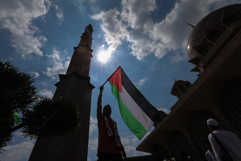 A silhouette of a man rise the flag of Palestine during the Save Jerusalem solidarity gathering at Putra Mosque December 22, 2017. — Picture by Ahmad Zamzahuri
