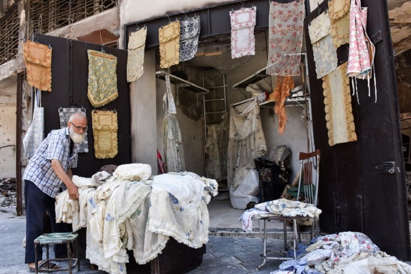A picture taken on July 22, 2017, shows 62-year-old Mohammad Shawash sitting outside his textile shop amid the destruction in the old city of Aleppo. u00e2u20acu201d AFP pic