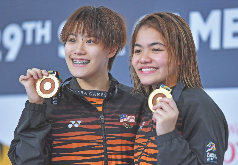 Wendy (left) and Nur Dhabitah display their gold medals after winning the womenu00e2u20acu2122s synchronised 3m springboard final of the 29th KL SEA Games. u00e2u20acu201d Bernama pic