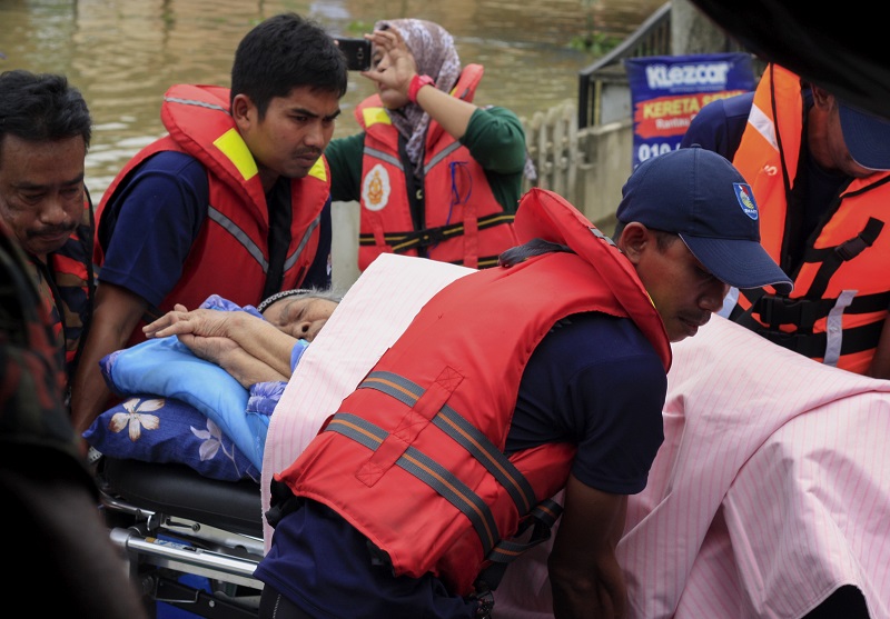 Rescue workers assist an elderly woman out of her home which was flooded in Rantau Panjang December 1, 2017. u00e2u20acu201d Bernama pic