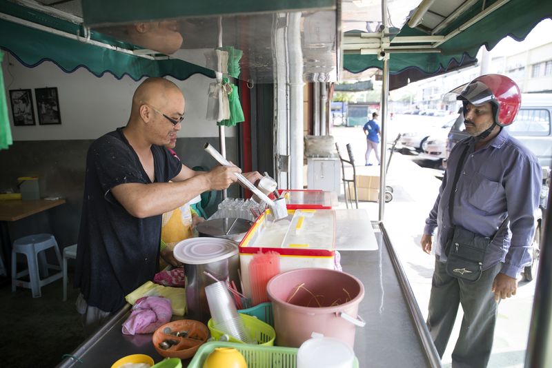 Ng Wei Lin preparing the soya milk for a customer at the Bean Milk Trading shop.