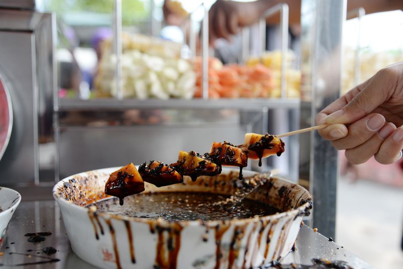 Skewered fruits on stick at the rojak tonggek stall has to be dipped into the rojak sauce first before eating.