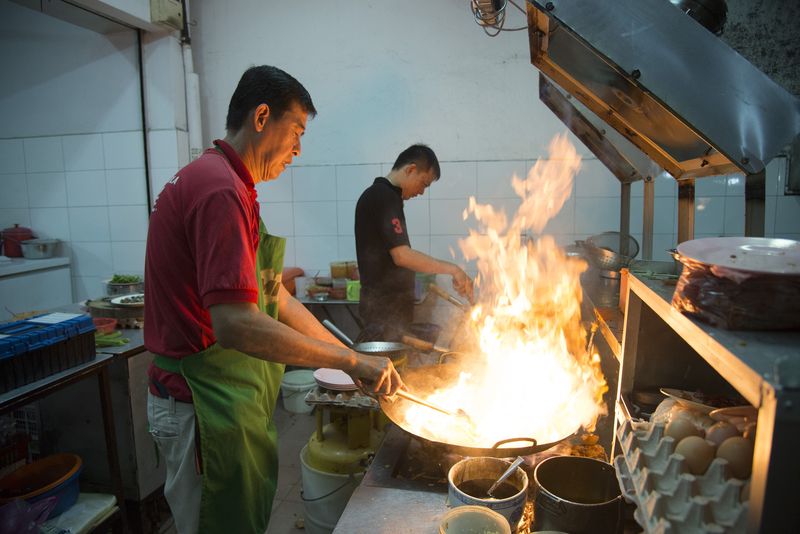The Ng brothers frying up the char koay teow at their stall.