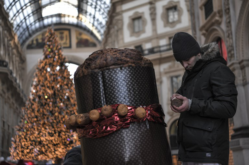A baker decorates a giant panettone on December 17, 2017 in the Vittorio Emanuele II gallery in Milan. u00e2u20acu201d AFP pic