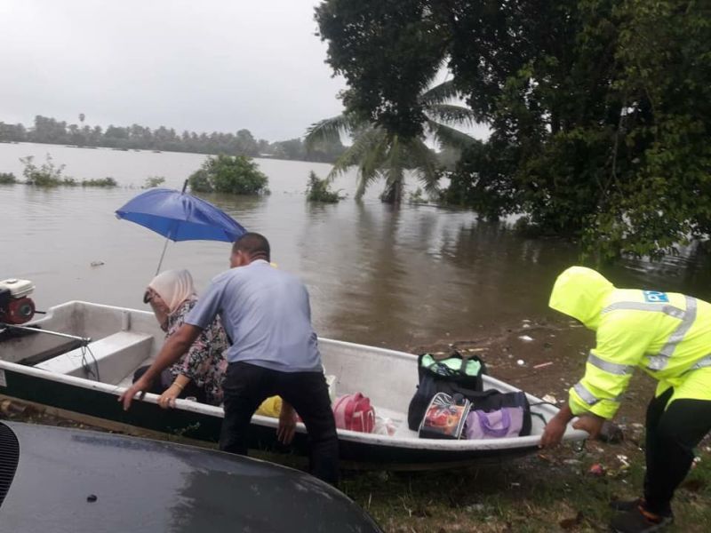 Anggota polis Tumpat membantu memindahkan mangsa banjir di Kampung Teluk Jering, 29 November 2017. u00e2u20acu2022 Foto ihsan Facebook/IPK Kelantan