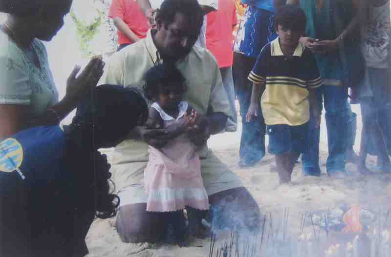 The family offering prayers a year after the December 26 tsunami struck for the continued good fortune of Thulaasi (then one-year-old) when the mammoth tsunami struck in 2004.