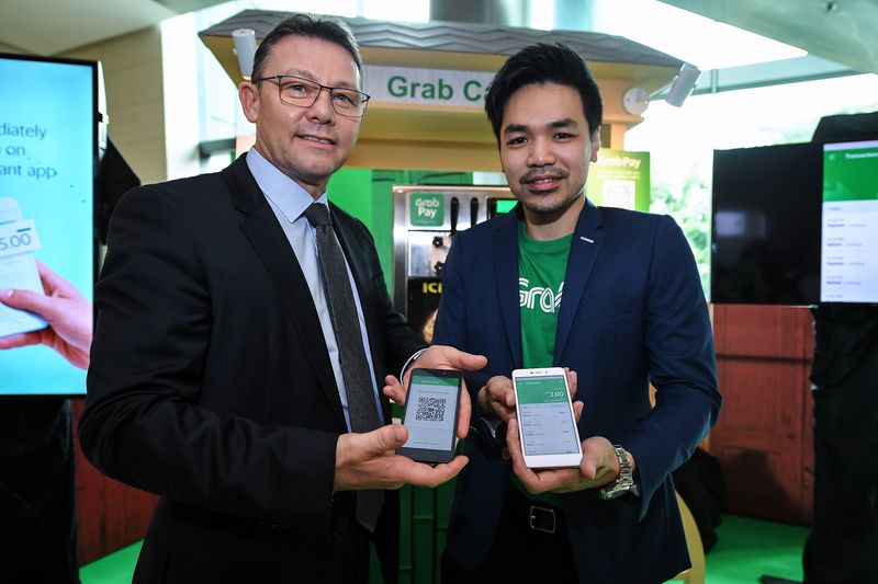 GrabPay Managing Director Jason Thompson with Grab Malaysia Manager Sean Goh (left) showing the QR code connecting apps at a payment system exhibition at Sasana Kijang, Kuala Lumpur December 8, 2017. u00e2u20acu201d Bernama pic