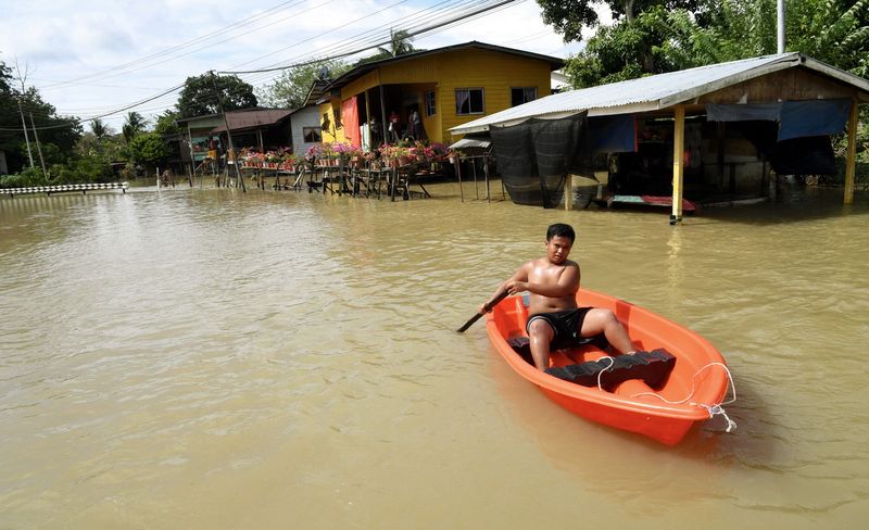 A resident of Kampung Bobot paddles a boat after the flood hit his village, December 12, 2017. Most of the villagers have been transferred to the temporary flood relief centre at Dewan Tun Said in Kota Belud. u00e2u20acu201d Bernama pic