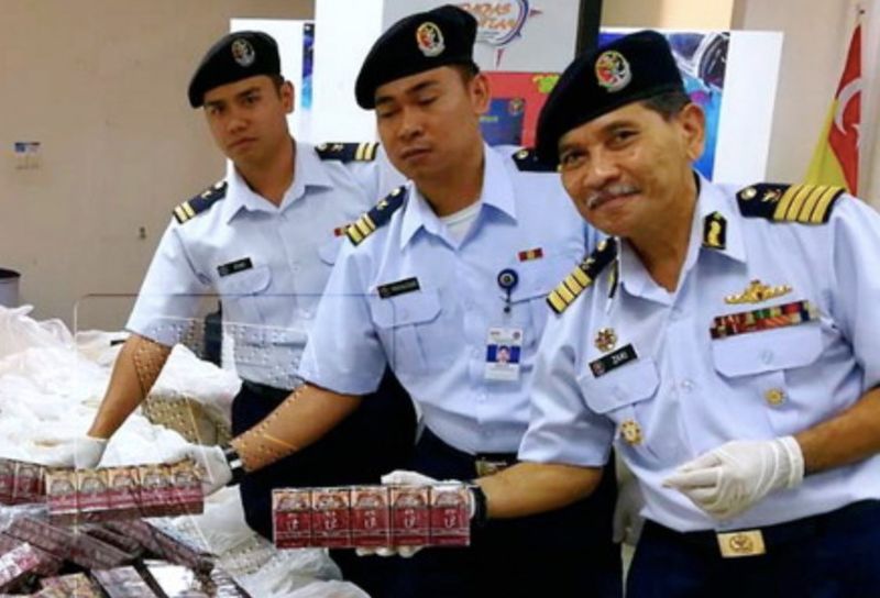 PELABUHAN KLANG, 13 Julai -- Pengarah Maritim Daerah Maritim 4, Kapten Maritim Abu Zaki Mohammad (kanan) menunjukkan sebahagian rokok putih jenama U2 yang cuba diseludup masuk ke Malaysia pada sidang media di Pejabat Daerah Maritim Klang (DM4)