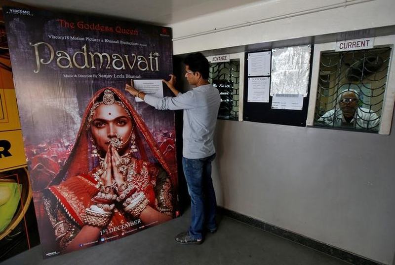 A worker tapes a message in support of the release of the upcoming Bollywood film 'Padmavati' on its poster at a ticket selling counter in a cinema hall in Kolkata November 28, 2017. u00e2u20acu201d Reuters pic 