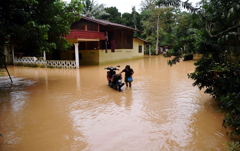 A resident of Kampung Kuala Semantan in Raub, Pahang, taking the opportunity to wash his motorcycle after his house was flooded December 8, 2017. u00e2u20acu201d Bernama pic