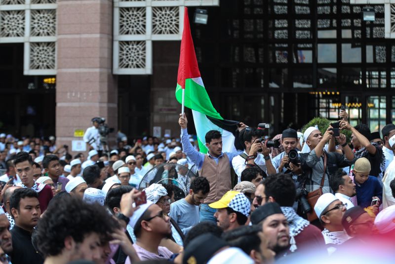 A man rises the flag of Palestine during the Save Jerusalem solidarity gathering at Putra Mosque December 22, 2017. u00e2u20acu201d Picture by Ahmad Zamzahuri